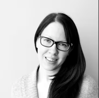 A black and white image of Carita Niskanen, a Solutions Architect in AWS, with dark hair and glasses.