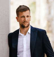 An image of Marin Varvodic, the CEO of Caelor, wearing a navy blue suit jacket and a white shirt.