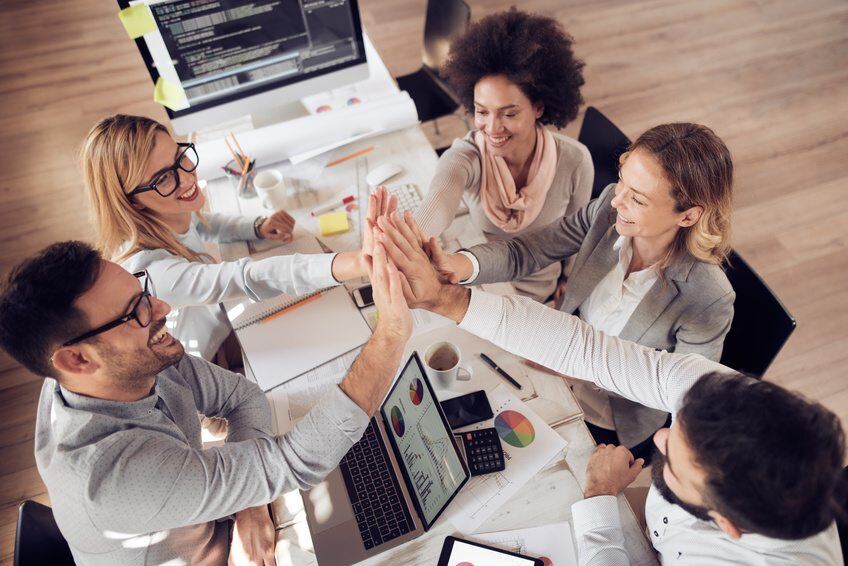 Happy team giving high five in office